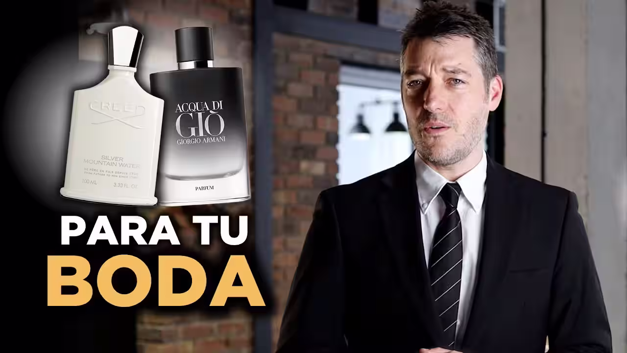Hombre con elegante traje de novio ajustándose la corbata junto a un frasco de perfume nicho sobre una mesa de cristal.